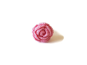 a realistic miniature of a pink rose on a ring